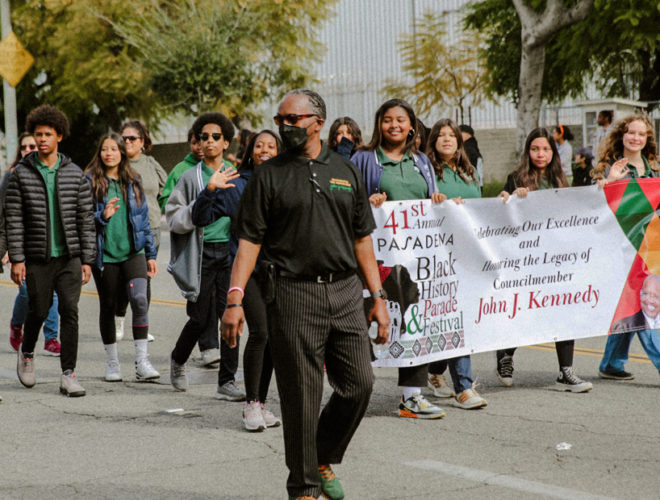A group of students holding up a banner that says 41st annual Pasadena Black HIsoty Parade & Festival Celebrating Our Excellence and Honoring the Legacy of Councilmember John J. Kennedy